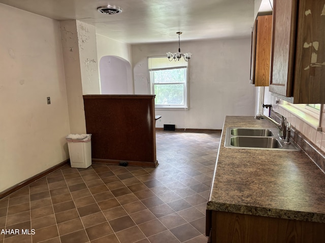 179 Orchard Way, Bedford, PA 15522 - kitchen featuring dark countertops, a chandelier, pendant lighting, and brown cabinetry