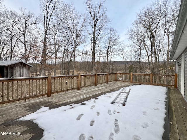 snow covered deck featuring an outbuilding