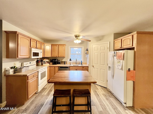 kitchen with a ceiling fan, white appliances, a sink, and light wood-style flooring