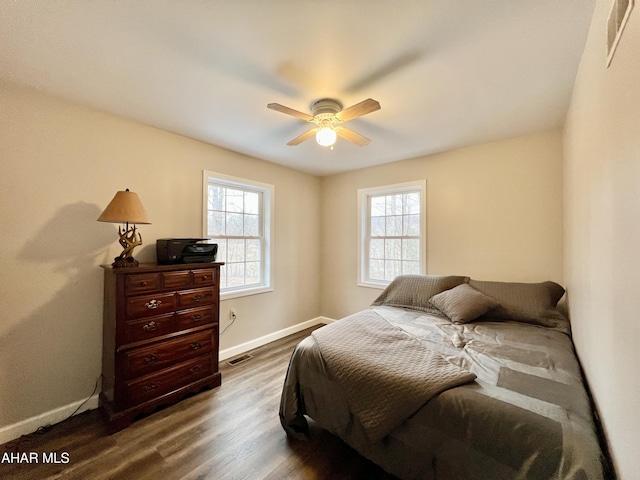 bedroom featuring ceiling fan, dark wood-style flooring, visible vents, and baseboards