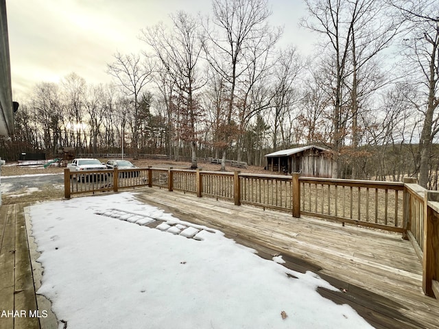 snow covered deck featuring an outdoor structure