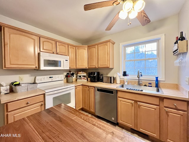 kitchen with light brown cabinets, light countertops, white appliances, and a sink