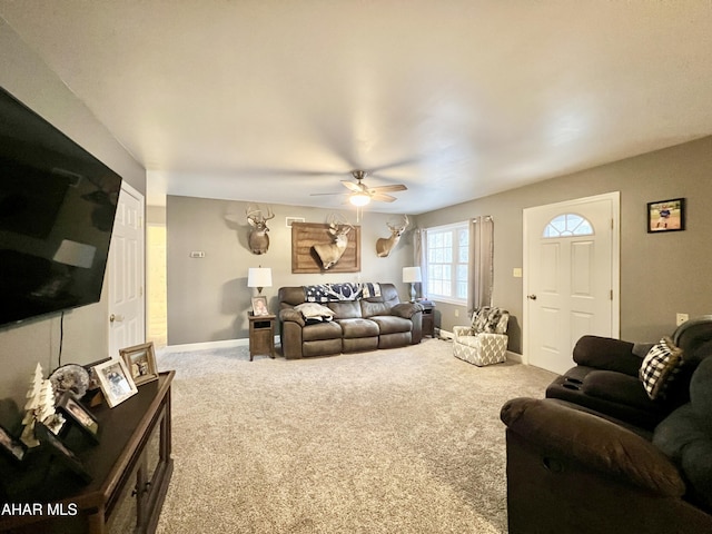 carpeted living room featuring a ceiling fan and baseboards