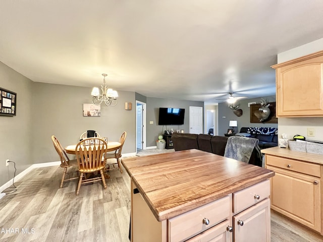 kitchen with light wood-style flooring, ceiling fan with notable chandelier, open floor plan, and light brown cabinetry