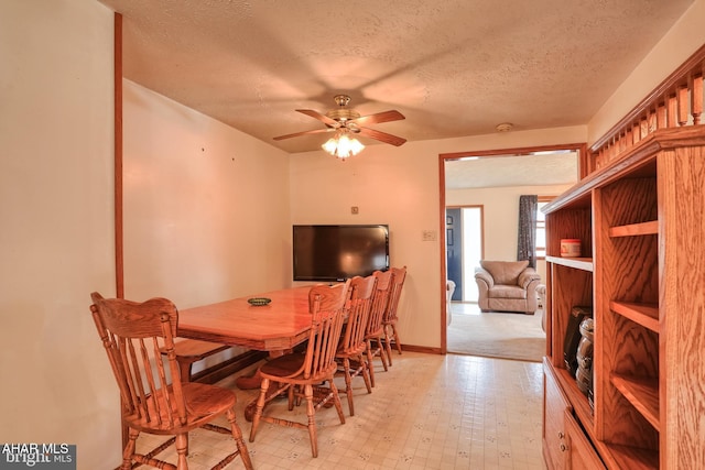 dining space with ceiling fan and a textured ceiling