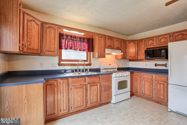 kitchen featuring sink, white appliances, and a textured ceiling