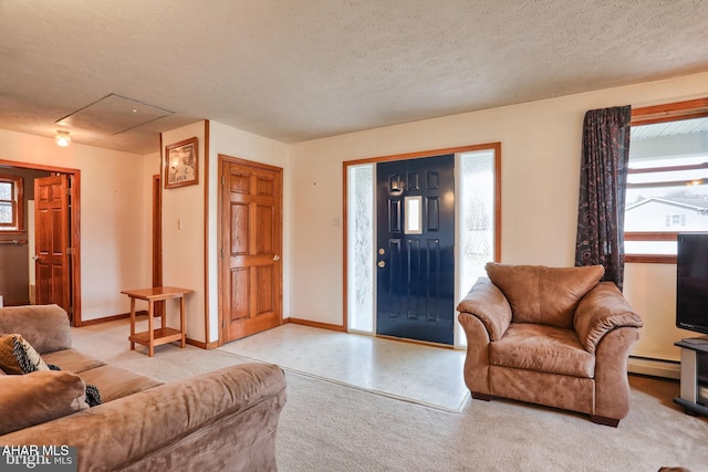 foyer with light carpet, a baseboard radiator, a textured ceiling, and a healthy amount of sunlight