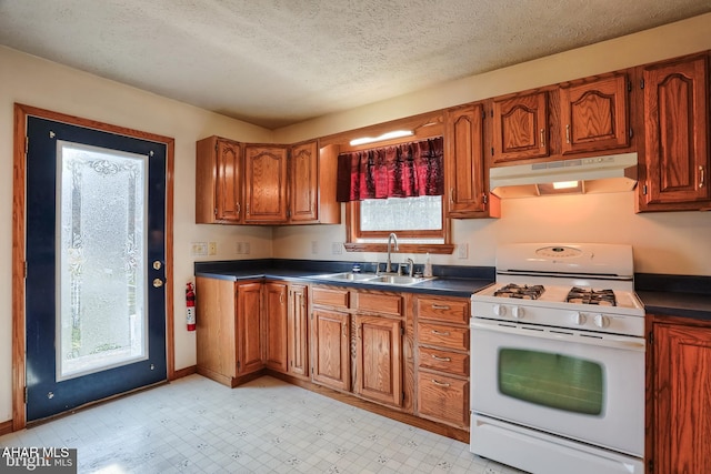 kitchen featuring sink, white gas stove, and a textured ceiling