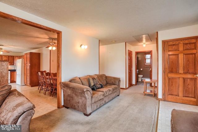 living room featuring ceiling fan and a textured ceiling