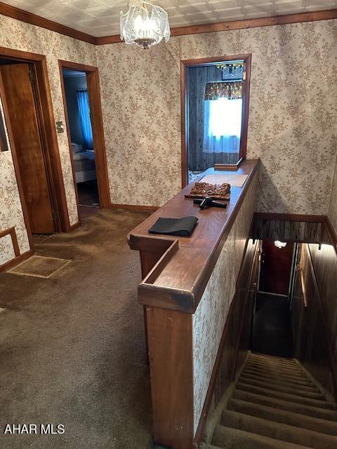 bar with crown molding, dark carpet, and a notable chandelier