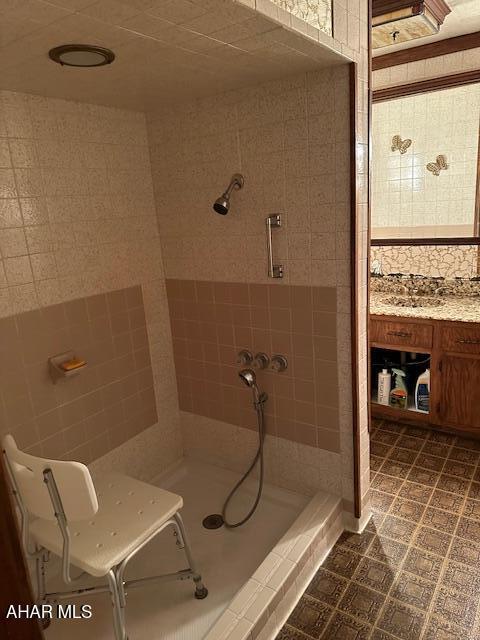 bathroom featuring tiled shower and vanity