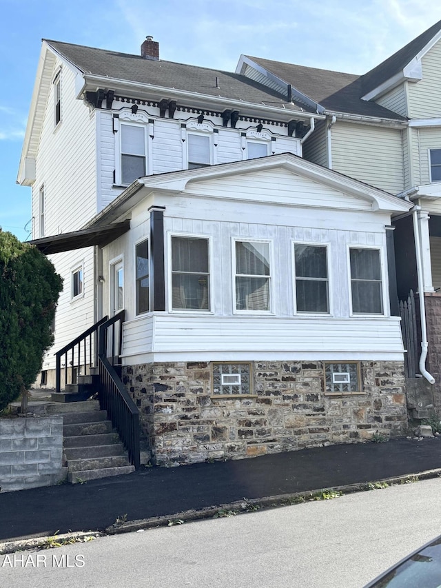 view of property exterior with a sunroom