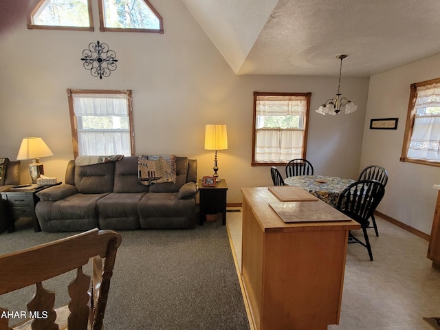 living area featuring a textured ceiling, baseboards, a notable chandelier, and vaulted ceiling