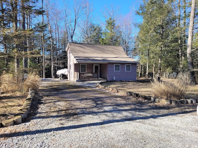 view of front of house with covered porch and gravel driveway