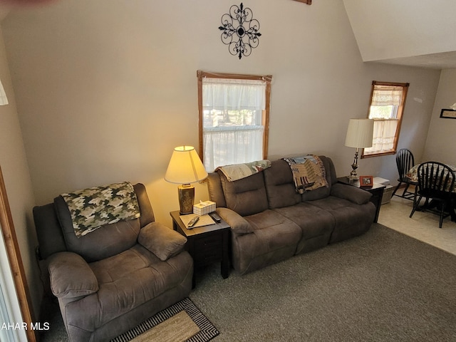 living area featuring vaulted ceiling, plenty of natural light, and carpet floors