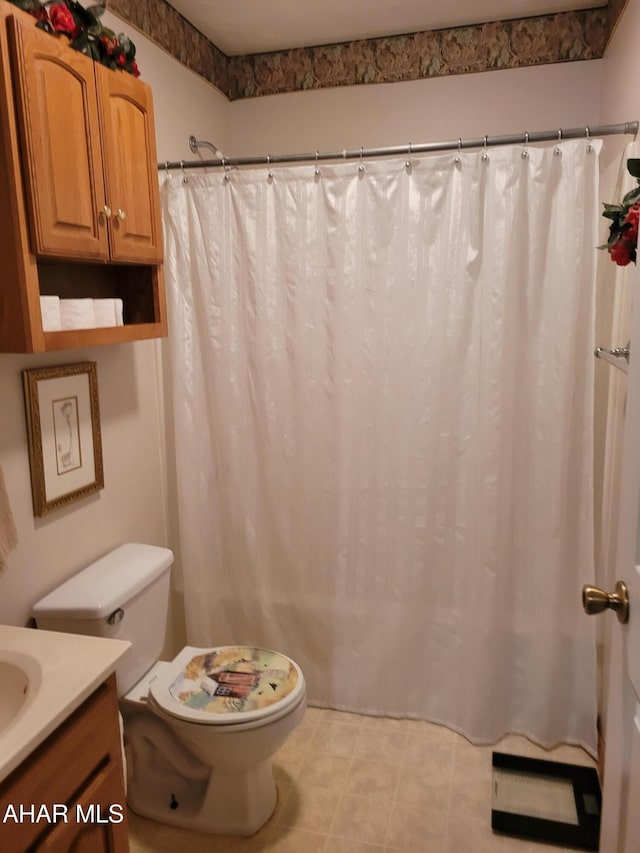 bathroom featuring vanity, a shower with shower curtain, and toilet