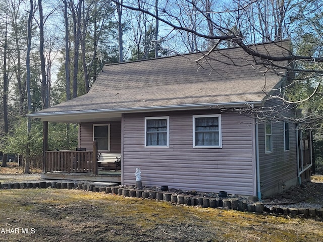 view of front facade with covered porch and a shingled roof