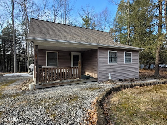 view of front of property with a porch and roof with shingles