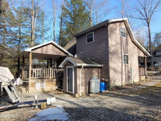 back of property featuring a deck and a shingled roof