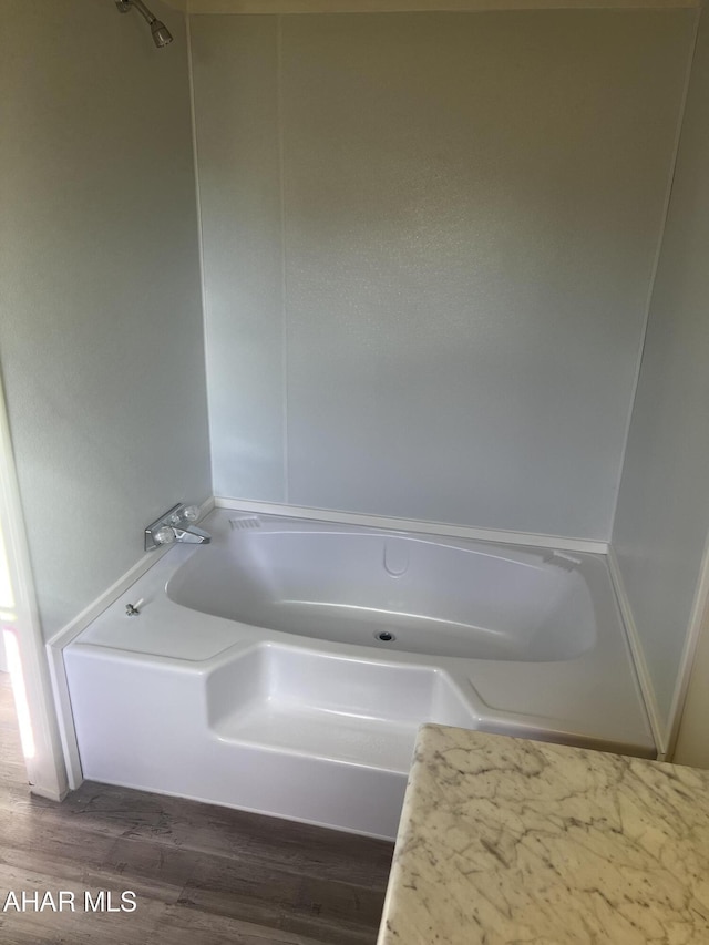 bathroom with wood-type flooring and a tub