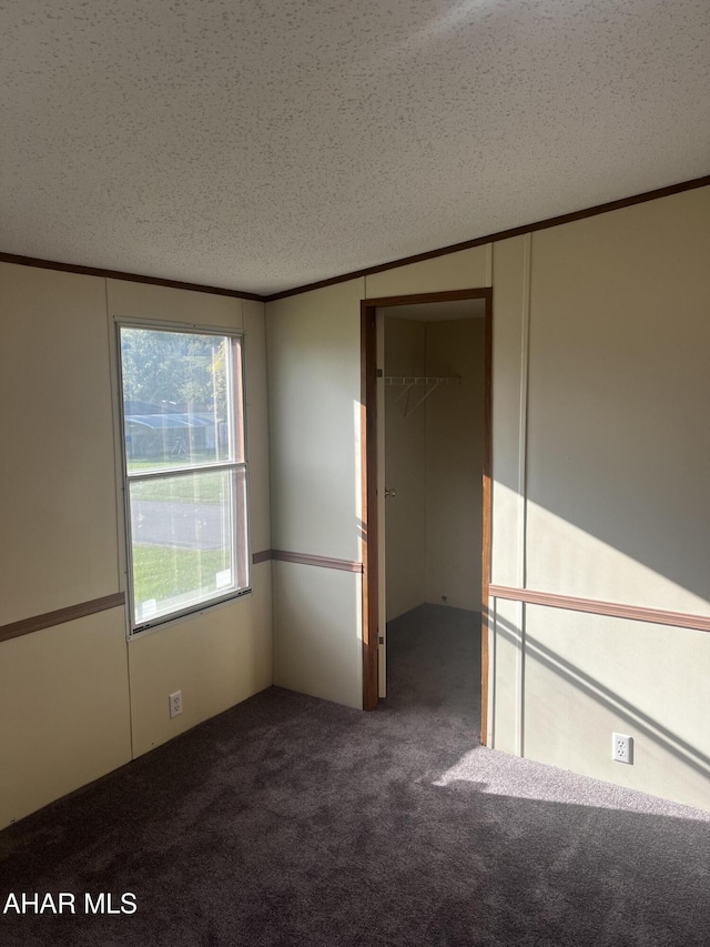 carpeted spare room featuring a textured ceiling and vaulted ceiling