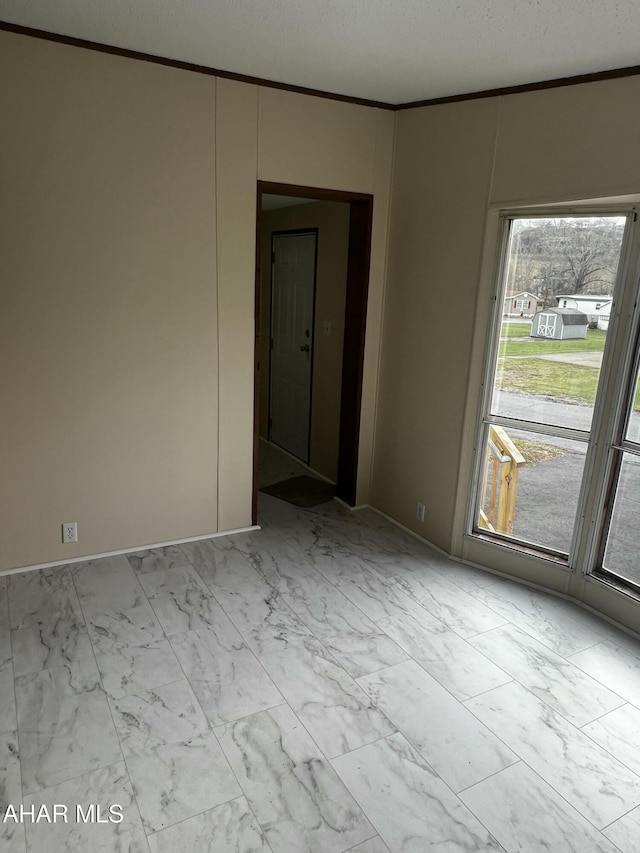 spare room featuring a textured ceiling and ornamental molding