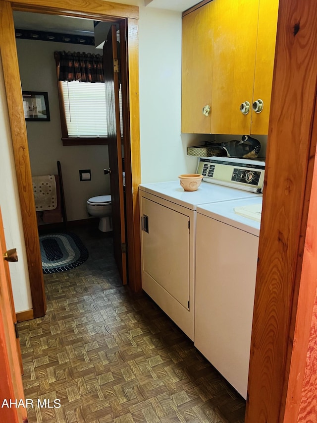 laundry room with separate washer and dryer, dark parquet flooring, and cabinets