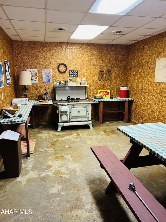 miscellaneous room featuring a drop ceiling and concrete floors