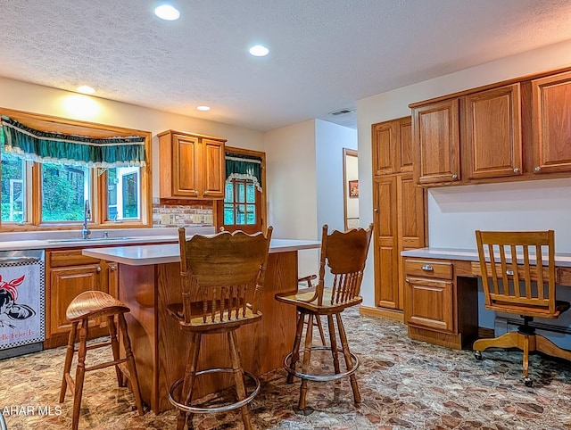 263 Helixville Rd, Schellsburg, PA 15559 - kitchen featuring dishwasher, a textured ceiling, brown cabinets, recessed lighting, and light countertops