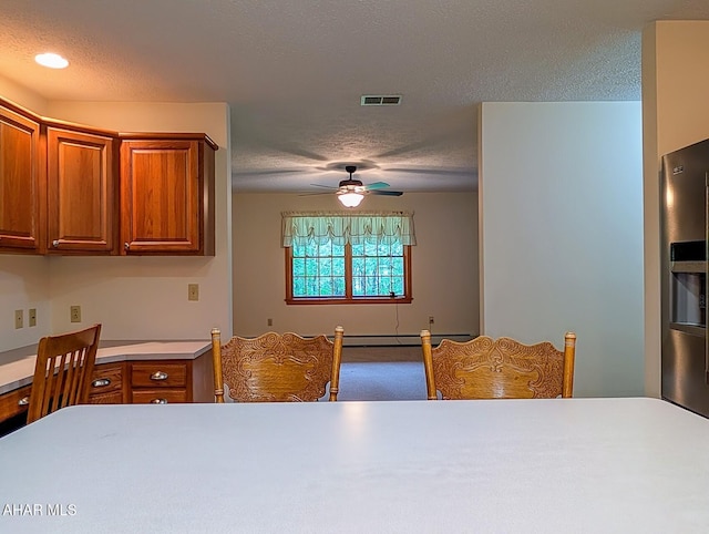 263 Helixville Rd, Schellsburg, PA 15559 - kitchen with a textured ceiling, brown cabinets, ceiling fan, light countertops, and baseboard heating