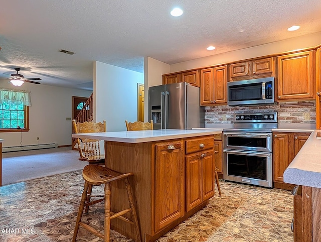 263 Helixville Rd, Schellsburg, PA 15559 - kitchen featuring appliances with stainless steel finishes, baseboard heating, a textured ceiling, light countertops, and brown cabinets