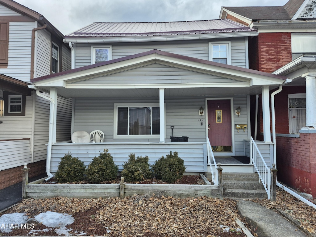 view of property with a porch and metal roof