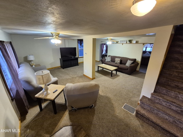 living room featuring stairs, ceiling fan, light carpet, and visible vents