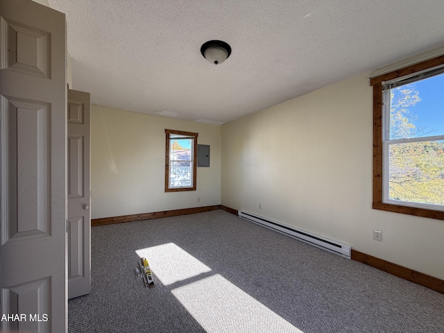 spare room with carpet flooring, a textured ceiling, electric panel, and a baseboard heating unit