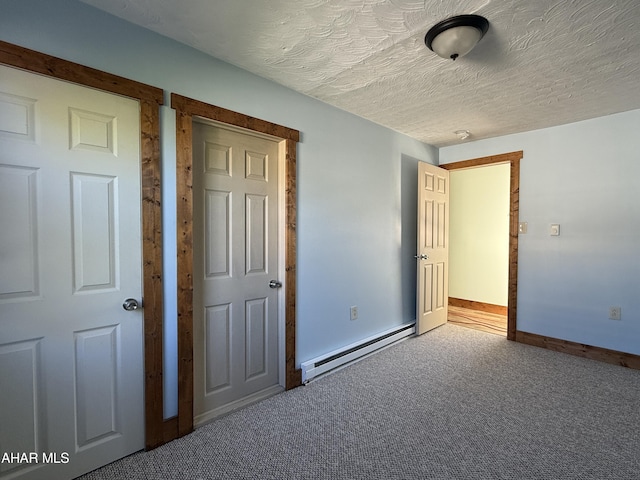 unfurnished bedroom with carpet flooring, a textured ceiling, and a baseboard heating unit