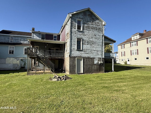 back of house featuring a yard and a deck