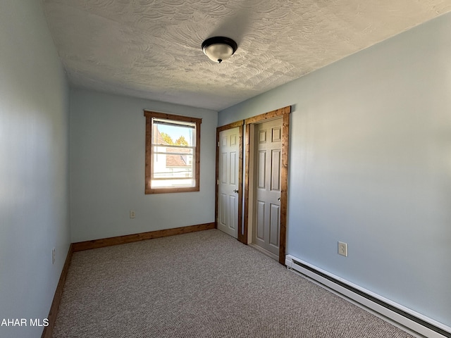 unfurnished bedroom with carpet flooring, a textured ceiling, and baseboard heating