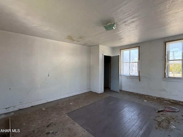 empty room featuring dark hardwood / wood-style flooring and a healthy amount of sunlight