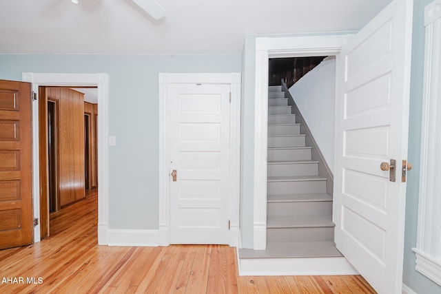 stairway with wood finished floors and baseboards