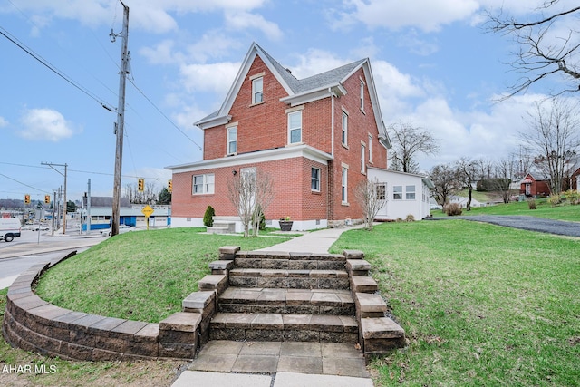 view of property exterior with brick siding and a lawn
