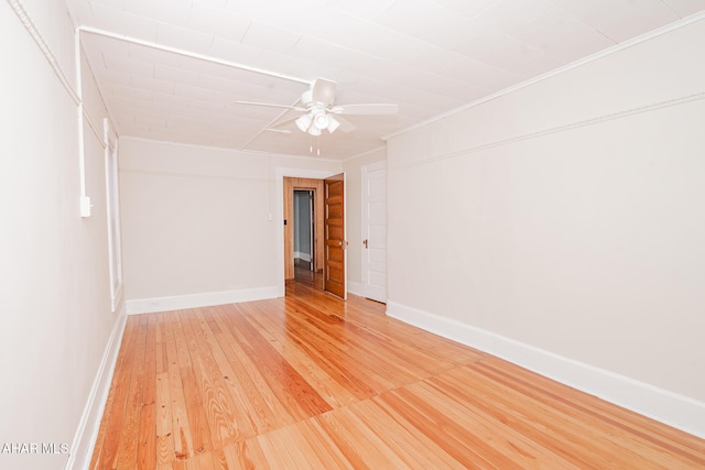 unfurnished room featuring ceiling fan, light wood-type flooring, baseboards, and crown molding