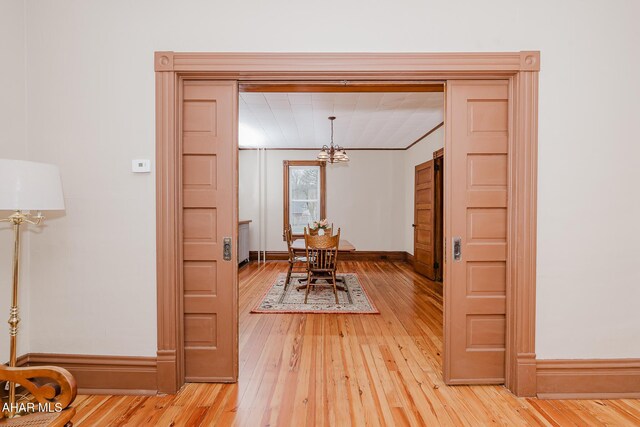 dining area featuring a chandelier, light wood finished floors, and baseboards