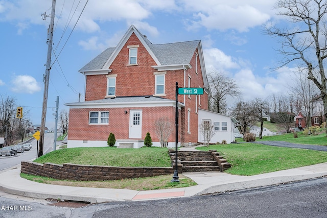 traditional-style home featuring brick siding, a front lawn, and roof with shingles