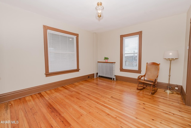 living area featuring radiator, baseboards, and hardwood / wood-style floors