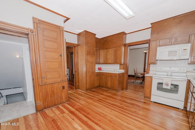 kitchen with white appliances, brown cabinetry, light countertops, light wood-style floors, and crown molding