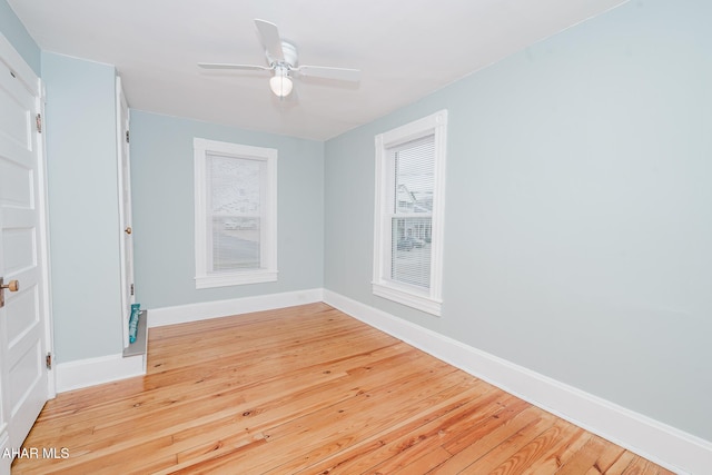 empty room with baseboards, light wood-type flooring, and a ceiling fan