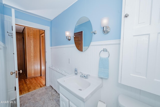 bathroom with wainscoting, toilet, and vanity
