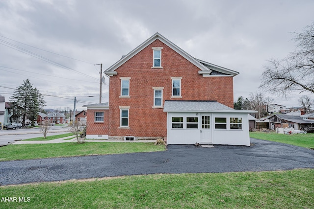 view of home's exterior featuring brick siding and a yard