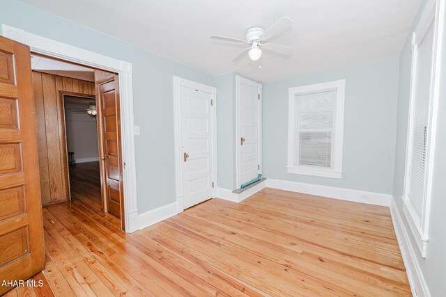 unfurnished bedroom featuring light wood-style flooring, baseboards, and ceiling fan