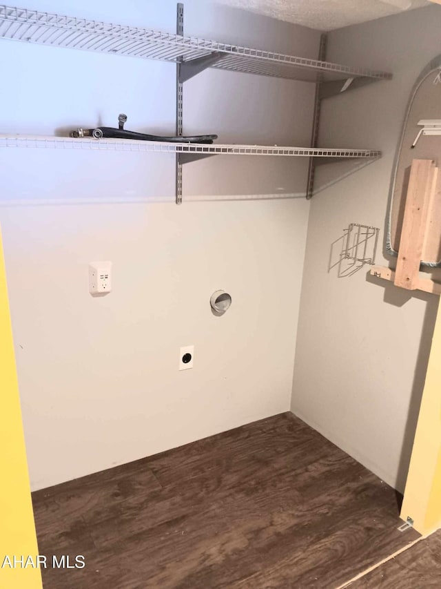 clothes washing area with dark wood finished floors and hookup for an electric dryer